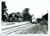 Korsberga station med motorvagn och ånglok på spåren.