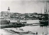 Fartyg intar trälast i norra hamnen. Till vänster syns Gustafskyrkan som brann ned under Luleå stadsbrand 1887.