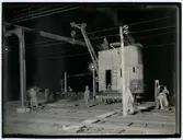 Med hjälp av en ångkran monteras balkarna till övergångsbron