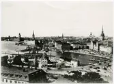 Statens Järnvägar, SJ, Stockholm utsikt från Katarinahissen 1930, innan slussbygget påbörjades och hissen rivits. Denna utsikt är numera historiskt. (bilden köpt 1935 från Svenska Turistföreningen.) Gamla riksdagshuset flygel mot Mälaren påbyggd och fullbordad år 1908 efter ritningar av Aron Jonsson. Uppgift från Stadsmuseets bildarkiv. 1956 06 12. Södra slöjdmagasinet och Mazettie ligger till höger om järnvägen.