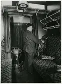 Tomteboda. Statens Järnvägar, SJ. Huvudverkstaden. Dammsugning av soffor i tågkupé. Dammsugare av fabrikat Lux typ IX.