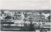 Värnamo station. Utsikts från Strandbergskulle. Halmstad-Nässjö Järnväg, HNJ. Första stationshuset byggdes 1877 och revs 1995. för att det stod i vägen för en planerad  vägkorsning. Första lokstallet byggdes 1875 men revs 1894 och ett nytt byggdes på annan plats på bangården. Ett nytt stationshus byggdes 1899 av Skånes-Smålands Järnväg, SSJ men byggnaden användes aldrig som järnvägsstation då SSj och HNJ enades om att använda HNJ station. 1902 byggdes ett nytt gemensamt stationshus vid godsmagasinet. 1903 anslöts Borås- Alvesta, BAJ hit och då byggdes ett nytt godsmagasin som  bekostades av BAJ. Detta magasin tillbyggdes 1918 och 1935. HNJs gamla stationshus flyttades 1902 och blev bostads- och överliggningshus.