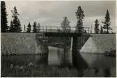 Järnvägsbro över Sågtjärnsbäcken.
Järnvägen som går genom Jokkmokks område sträcker sig över många vattendrag, bäckar, åar och älvar. Broarna som byggdes över de anpassades till terrängen. De var framförallt funktionella men, deras utseende gick från väldigt enkla, grovhuggna till sublima, estetiskt utformade valvbroar.