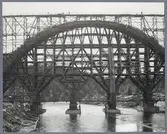 Järnvägsbron över Öreälven under byggtiden, med arbetare på bron.
