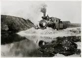 Ånglok kör igenom översvämmning på Malmö Simrishamns  Järnväg, MSJ 1910.