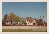 Vy vid Veddige. Station anlagd 1880. Tvåvånings stationshus, putsat byggt 1920 enligt arkiterk Harald  Söderberg, Varberg. Elektrisk växelförregling.