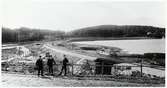 Personerna från vänster i bild: August Carlsson - grosshandlare, Shultz - ingenjör från danmark, Heine - Stins på Släps station, står framför den färdigställda delsträckan någonstans mellan Munkekullen - särö västerskog.