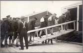 Transport med båt över Torne älv med ryska skadade krigsfångar i Haparanda under Första världskriget.