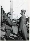 Ett tyskt och ett svenskt befäl hälsar på varandra när ett tyskt sjukvårdståg passerar Hallsberg under Andra Världskriget.