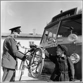 Busschauffören hjälper en pojke med hans cykel. Köping-Utterberg-Riddarhyttan, KURJ.