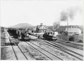 Repbäcken station. Tåg från Södra - Dalarnas Järnväg, SDJ till vänster och till höger ett av Västerdalsbanans tåg, GDJ. SDJ-tåget i riktning mot Rättvik och GDJ-tåget mot Björbo.