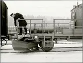 Trafikaktiebolaget Grängesberg–Oxelösunds Järnvägar, TGOJ Q 9452, man på spårrensarvagn.