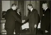 Direktör Erlander Waldenström skakar hand med Erik Upmark, Trafikchef Granfeldt står till höger. från Statens Järnväg, SJ:s 100 årsjubileum 1 december 1956.