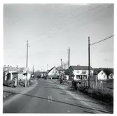 Järnvägsövergång i Rosenfors med en bensinmack till vänster och affär till höger.