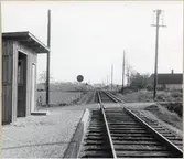 Järnvägsövergång vid Brunnslöv med kombinerad vakt- och hållplatskur.