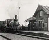 SWB A 4 vid Virsbo Station. I tjänst 1873-1924 f.d. Sala-Tillberga Järnväg nr 2. Tillverkningsnr 2349 firma Sharp, Stewart & Co i Manchester. Nr 4 fick ny panna 1914. Stationsmästaren är Gustaf Alfred Fors född 17/1 1857. Mannen till vänster är stationskarl nr 252 Oskar Larsson född 21/3 1875.