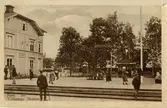Tillberga station 1907-1926. Del av stationshus och resenärer på plattform. Ekegren nr 121