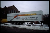 Lastbilssläp med text på holländska: NS Goederenvervoer zet het op de rails.