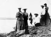 Sex kvinnor, varav en i folkdräkt, fotograferade på en klippa vid Mjörn. Bilden tagen i samband med utflykt med båten Jonas Alströmer.