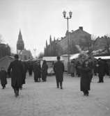 Hindersmässan i Örebro den 28 januari 1937. Människor spankulerar omkring på Stortorgets östra del, och de flesta rör sig i riktning mot marknadsstånden en bit bort. Nikolaikyrkan syns längst bort vid Stortorgets västra ände.