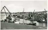 Vy över Järnvägsbassängen och massamagasinen vid Rosenborg. Kolhögar och lastande fartyg vid kajerna. Vykort.