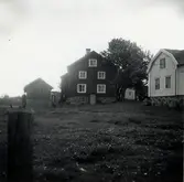 Två hus i gårdsmiljö.