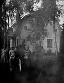 MOR OCH FAR MED SINA FYRA BARN UTANFÖR ETT HUS