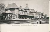 Stationsbangård och barn vid spårsida av station.