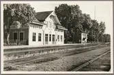 Spårsida av station med vy på stationshus och ställverksbyggnad.