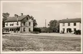 Stationshus och postkontor med del av bangård i bild.