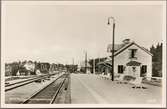 Stationsområde och bangård med järnvägsbro i bakgrunden.