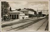 Stationsområde med vy på stationshus och elektrifierad bangård.