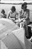 Två damer i solglasögon och en flicka sitter sommarklädda ombord på en båt, troligen en Getteröbåt. Den ena kvinnan har en filt i knät.
(Se även bildnr EA0813, EA0822, EA1156, EA1068)