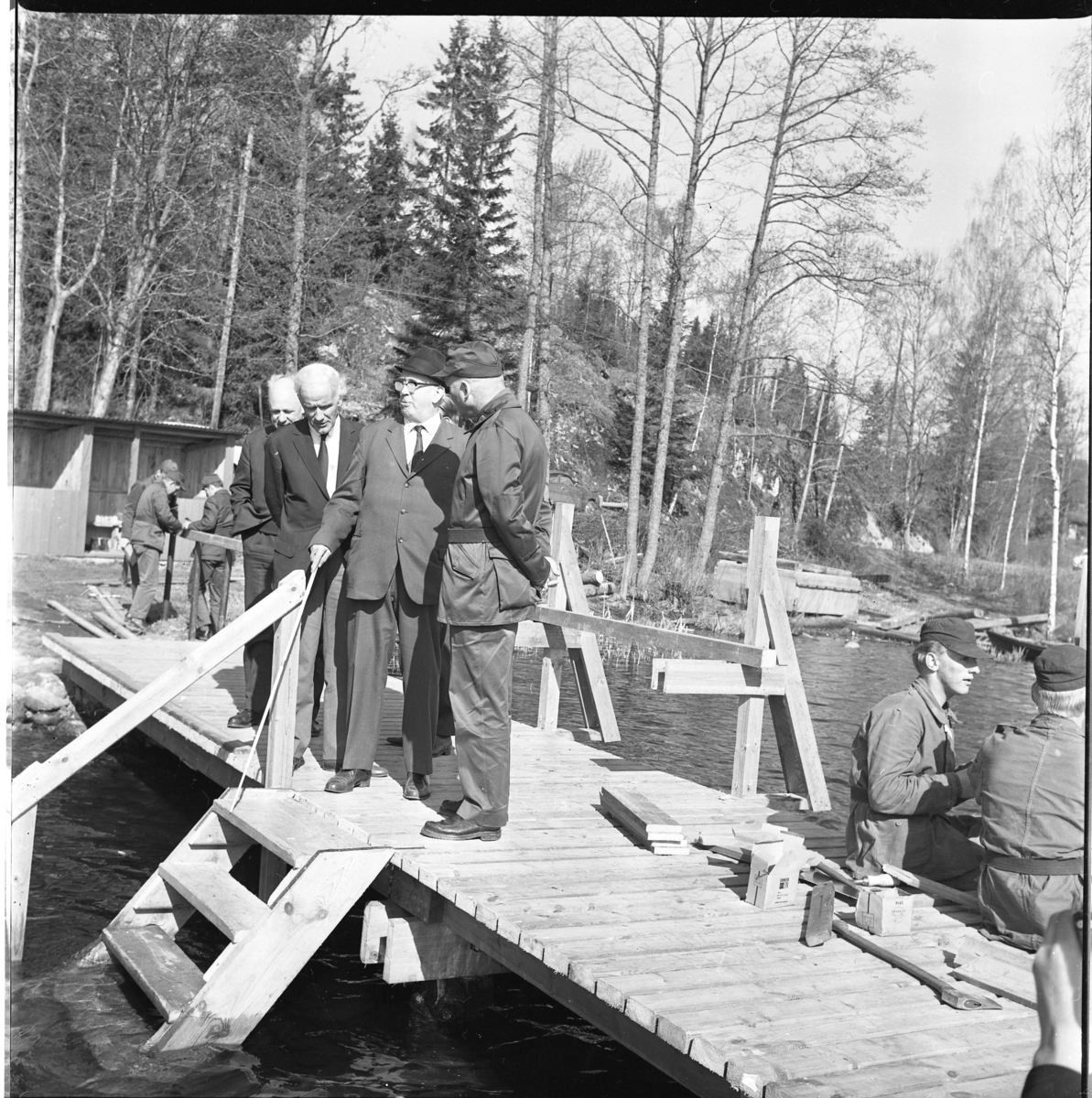 Percy Heldebrandt, Men on a bathing bridge at the Blind Home in Bunn. Standing from the left is the parish priest Tore Lord. In the foreground, some younger men are in military attire on the dock among carpenter tools - they look to be dressed in military attire.