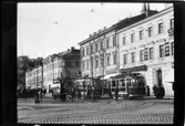 Vy över torget vid Södra kajen - Norra Esplanadgatan i Helsingfors. Helsingin Kaupungin Liikennelaitos, HKL spårvagn 46 och 37 ses mitt i bild, till vänster om vagnarna ses en hästtransport.