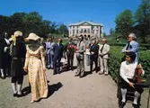 Kungabesök på Gunnebo slott, år 1977. I mitten ses Kung Carl  XVI Gustaf hållandes en  blombukett. Längst till vänster Jan Ivar Blixt. Till vänster om kungen står rektor Åke Baaz och landshövdingen Erik Huss. Längst åt höger står fil.dr. Nils Dahlbeck och chefrededaktör Jon E. Lisshammar. mannen som sitter på en stol längst ut till höger är Ivan Hagberg.
Vykort, förlag: Mölndals Kommun.