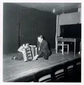 En pojke och en man sitter på en scen med ett dragspel.