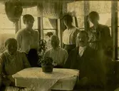 Lilla Vommedal, verandan, Streteredsv. 25 3/10 1920.
Fr.v. 1. Anna Bengtsson f. 1839 d. 1931, Lilla Vommedal.
2. Anna Johansson f. 1891 d. 1977, Alegårdsslätt, Fässberg.
3. Maria Gustafsson f. 1858 d. 1944, Lilla Vommedal.
4. Ester Jakobsson f. 1896 d. 1926, Lilla Vommedal. Fosterdotter.
5. Anton Gustafsson f. 1873 d. 1948, Lilla Vommedal. 
6. Esters kusin, Grebbestad?
Nr. 3 och 5 gifta, nr.4 fosterbarn hos nr. 3 och 5, nr. 1 faster till nr. 3.