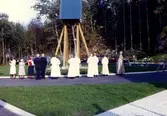 Invigning av Apelgårdens kyrka, Svenska kyrkan, 1982. Biskop Bertil Gärdtner, flera präster och övriga står framför klockstapeln.