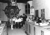 En barnkör som sjunger under ledning av organist Eva Karlsson i Kållereds kyrka, Svenska kyrkan, innan 1976.