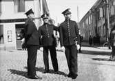 Stadspoliser från Västerås patrullerar på Stora torget under Arbogautställningen.
Tre poliser i uniform och handskar står utanför speceriaffären på Stora torget.