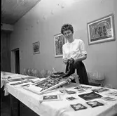 ABF har kursavslutning. En kvinna visar flamskvävnader.