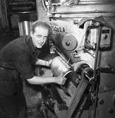 Arboga Tidning, personal och interiör. En man, med uppkavlade skjortärmar, arbetar vid tryckpressen.