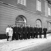 Polisens personal, samlad utanför polisstationen. Fjorton män och tre kvinnor. Alla bär uniform utom de två kvinnorna till vänster.
Från vänster: Göta Viola Eriksson, Inga Jansson, Bo Hammar, Lars 