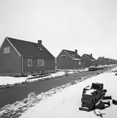 Nybyggda villor på Rydaholmsgatan. Modellen kallas Arbogavillan lll.
Några bilar står parkerade på gatan. Ett snötäcke ligger på marken. I förgrunden ligger en hög med tegelstenar.