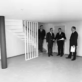 Arbogavillan lll, interiör. Fyra herrar inspekterar nybygget och studerar ritningen. De står vid trappan till övervåningen. Där finns en spaljé.
Från vänster: Norberg, verkmästare på Byggnadsfirma Lund, Hilding Karnéus, Arboga Sparbank, Hilding Lund, Byggnadsfirma Lund och Zackrisson, chef på Arboga Sparbank.