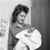 Arbogas förstfödda i januari 1960.
Kvinna med nyfött barn  i famnen. Barnet är inlindat i en filt.