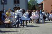 Arbogaträffen
Square dance-uppvisning på ett uppbyggt dansgolv på Stora torget. Kvinnorna har vida kjolar och underkjolar. I bakgrunden syns butik Lyktan.