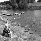 Barn som badar vid Villagatsbadet. Badbryggor i Arbogaån. Västerbron till vänster.