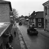 Tre bandvagnar på Nygatan. En militärtransport från Enköping.
Posten närmast till vänster, Nikolaiskolan närmast till höger.